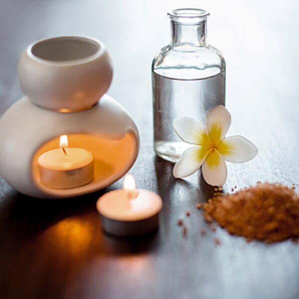 A tranquil spa table adorned with a relaxing candle and delicate flower, offering rejuvenating treatments with the added touch of invigorating salt. Ideal for vacation rental services seeking to create a serene oasis