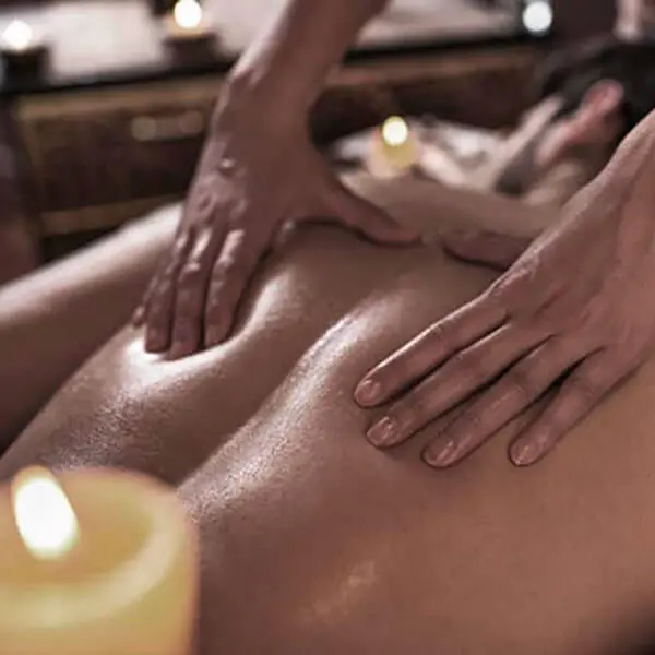 A man enjoying a soothing back massage at a luxurious spa during his vacation.