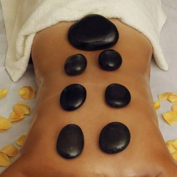 A woman utilizing vacation rental services with black stones on her back.