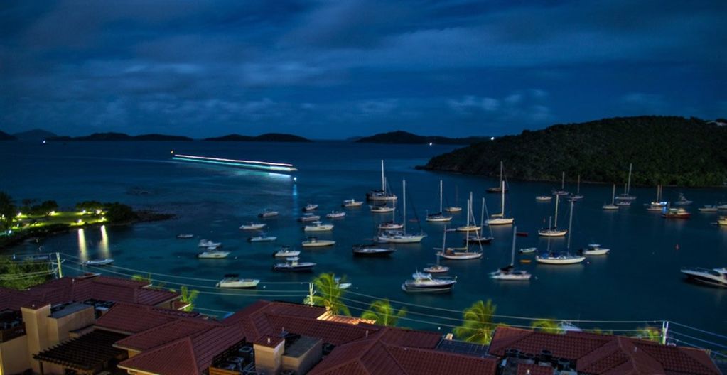 A view of boats docked in a marina at night, ideal for St John vacation rentals seekers.